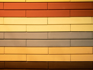 abstract pattern wall made of different colors bricks - orange, red, brown, gray and yellow