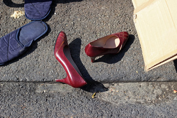 Red high heeled shoes in trash junk city street