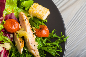 Healthy chicken salad with lettuce, grilled tomato, croutons, shredded cheese and grilled chicken