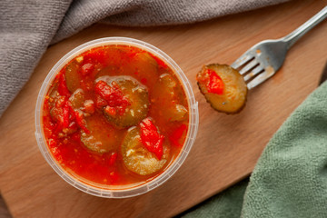 Spicy salad in the package. View from above. Salad of vegetables and spices in plastic packaging in the kitchen. Lecho of cucumbers, tomatoes, peppers and spices.