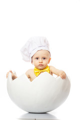 Portrait of a little adorable infant baby sitting in egg shell. Little Chef. isolated on white