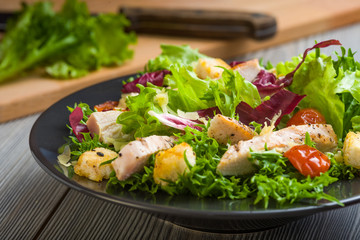 Healthy chicken salad with lettuce, grilled tomato, croutons, shredded cheese and grilled chicken