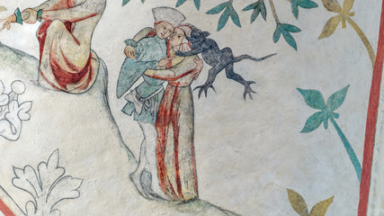 Medieval church fresco from Odsherred in denmark. A young couple embraces each other while a devil sits on the woman shoulder and whispers trying to make er break the commandment about adultery.