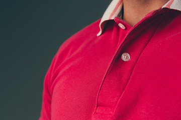 Close up of a young adult caucasian male wearing a red polo shirt