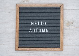 Hello autumn text on wooden letter Board in white letters on grey background