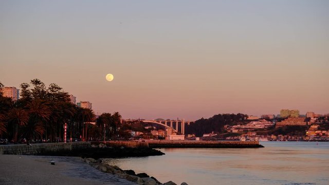 Time lapse video of full moon rising over night river Douro, Porto, Portugal