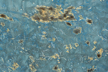 texture of blue wall with yellow spots of paint and rust