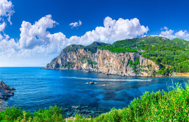 Beautiful summer panoramic seascape. View of Paleokastritsa famous beach in close bay with crystal clear azure water on Corfu island, Ionian archipelago, Greece.