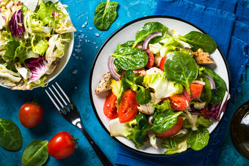 Green salad with chicken and vegetables top view.