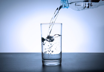 water in drinking water bottle is pouring into a glass 