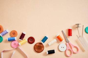 tools for needlework thread scissors and tape measure isolated on biege background