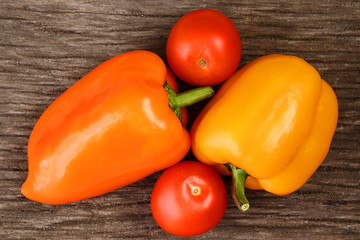 Bright vegetables and fruits (yellow and orange peppers, red tomatoes, yellow lemon, green dill).