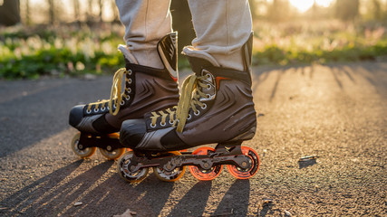 Close view to inline skates . Outdoor inline skating on smooth concrete ground. Spring Background...