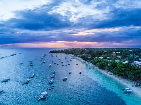 Aerial Drone Panorama Picture of the white Alona Beach during Sunset in Panglao, Bohol in the Philippines