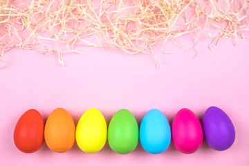Colored Easter eggs on pink background. Flatlay.