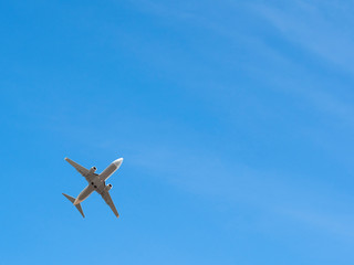 Plane flying at clear blue sky background with copy-space. Airplane transportation