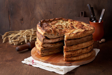 Various Traditional Ossetian meat pies with beef, chicken and salmon on a wooden background