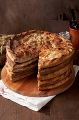 Various Traditional Ossetian meat pies with beef, chicken and salmon on a wooden background