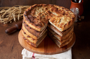 Various Traditional Ossetian meat pies with beef, chicken and salmon on a wooden background