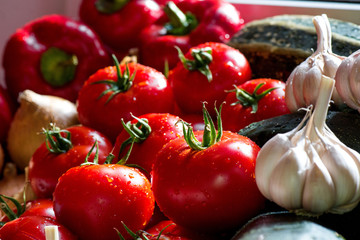 Ripe fresh harvested vegetables on table. Onions, tomatoes, garlic, pepper, zucchini in kitchen. Making delicious vegetarian meal or canning veggies for winter in jars. Concept of healthy eating