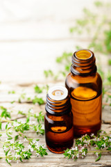 thyme essential oil and thyme flowers on the wooden board
