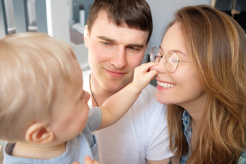 The child plays with his parents in the nursery. Happy family concept