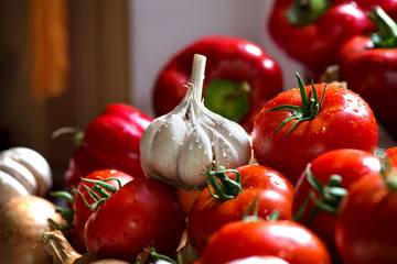 Ripe fresh harvested vegetables on table. Onions, tomatoes, garlic, pepper, zucchini in kitchen. Making delicious vegetarian meal or canning veggies for winter in jars. Concept of healthy eating