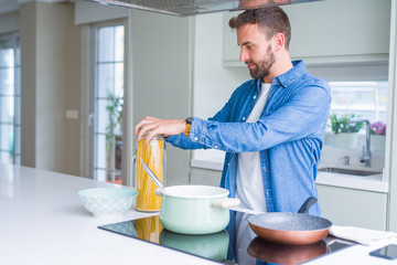 Handsome man cooking pasta at home