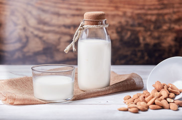Glass of almond milk on the wooden table 