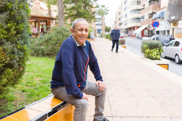 Handsome middle age senior man smiling cheerful, happy and positive sitting at the park