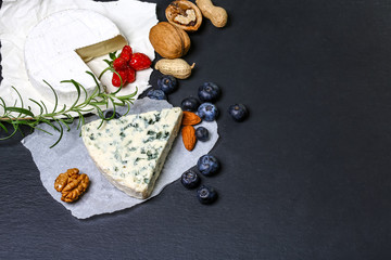 Various types of cheese on wooden background. French national food. Cheese with mold. A delicious appetizer for wine, copy space