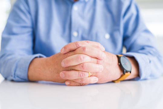 Close up of man hands with crossed fingers over white table
