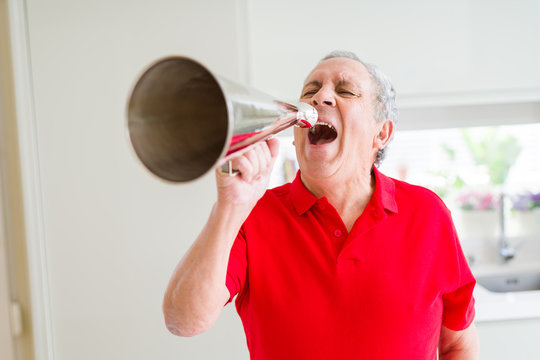 Senior man shouthing excited through vintage metal megaphone