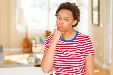 Young beautiful african american woman at home thinking looking tired and bored with depression problems with crossed arms.