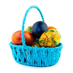 Easter eggs in a blue basket isolated on white background