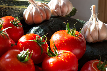 Ripe fresh harvested vegetables on table. Onions, tomatoes, garlic, pepper, zucchini in kitchen. Making delicious vegetarian meal or canning veggies for winter in jars. Concept of healthy eating