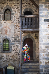 The mask of Arlecchino. On the stairs of the house