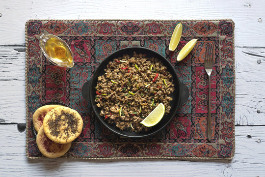 Indian minced meat Qeema on a white wooden table.