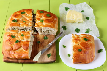 Freshly baked fish pie on a green wooden table.