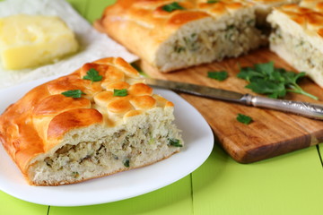 Freshly baked fish pie on a green wooden table.