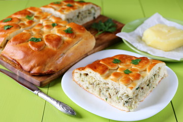Freshly baked fish pie on a green wooden table.
