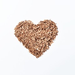 heart-shaped wood saw dust on dirty white background