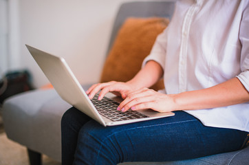 Naklejka premium Close up of woman's hands typing on laptop keyboard at home - Image