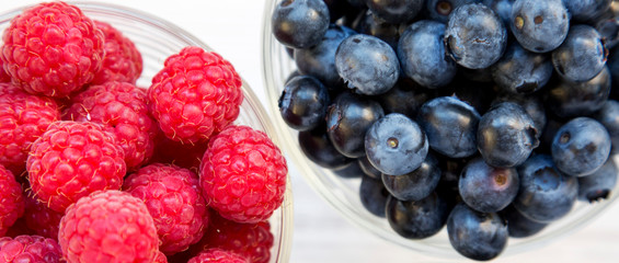 Full bowls of blueberries, and raspberries, top view. Healthy eating and dieting. Overhead, from above.