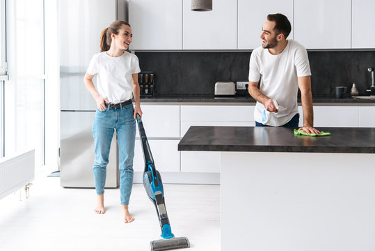 Happy Young Couple Cleaning Kitchen Together