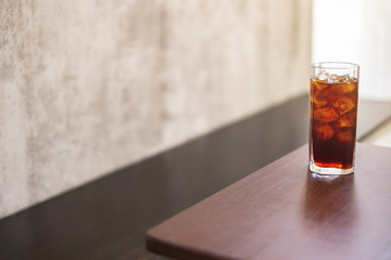 iced coffee glass and book on wooden table
