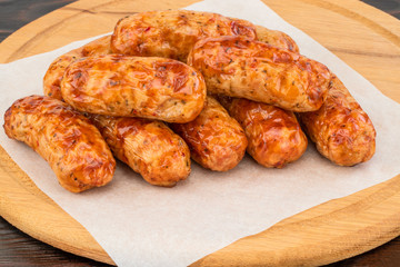 Tasty grilled sausage on the wooden background