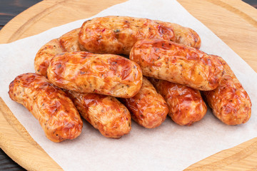 Tasty grilled sausage on the wooden background