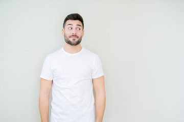 Fototapeta premium Young handsome man wearing casual white t-shirt over isolated background smiling looking side and staring away thinking.