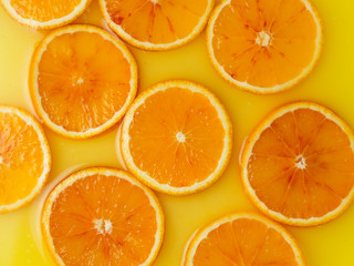 Top view of red orange slices in juice as background